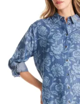 Camisa de lyocell con estampado floral en tonos azules, cuello con solapa, cierre frontal con botones y mangas largas regulables con presilla.