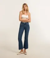 Pantalón de jean corte flare cropped, de tiro alto, con diseño ajustado en caderas y muslos, y botamanga acampanada con terminación deshilachada.