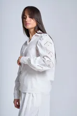 Camisa blanca de mangas largas con broderie y botones perlados.