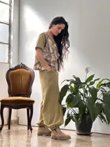 Conjunto compuesto por una remera de cuello redondo y un pantalón tipo balloon de tiro alto con puños elásticos en los tobillos y bolsillos laterales. Ambas prendas están confeccionadas en rib de algodón color verde oliva.