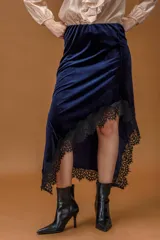 Falda midi de terciopelo azul marino con corte asimétrico y terminación de encaje negro en el ruedo.