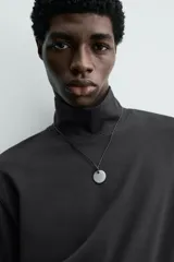 Camiseta de hombre manga larga y cuello perkins, de calce regular fit y color negro, confeccionada en tejido compacto de algodón.