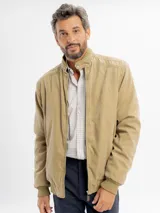 Campera de estilo casual color beige, con cierre frontal, cuello alto y puños elásticos acanalados.