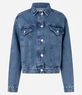 Campera de jeans de corte boxy, color azul medio lavado, con cuello, cierre frontal de botones, bolsillos con solapa y botones en el pecho, y recortes visibles.