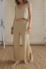 Pantalón acampanado color dorado, de lurex y viscosa, con tajo pequeño a los costados.