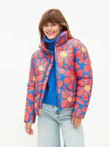 Campera puffer corta con estampado de flores rojas y azules sobre fondo naranja.