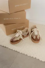Championes urbanos de diseño acolchado, combinando tonos marrones, beige y detalles metalizados con textura. Cuentan con cordones al tono y suela de goma color caramelo.
