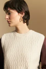 Chaleco tejido de punto en color azul marino, con diseño de textura sutil en relieve, escote redondo y terminaciones acanaladas en cuello, sisas y ruedo.