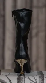 Bota corta de cuero sintético negro con tacón fino dorado de diseño esculpido y punta fina.