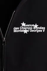 Campera con capucha negra, de corte holgado (boxy), con cierre bidireccional y bolsillos canguro delanteros.