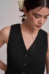 Chaleco corto de corte sastrero en color marrón, con escote en V y cierre frontal con botones a tono.