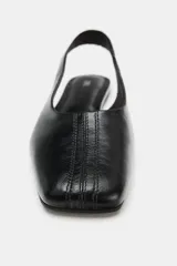 Zapato plano destalonado de piel con escote redondo, tira trasera elástica y punta cuadrada.