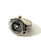 Reloj anillo plateado con esfera negra y números arábigos.