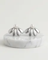 Caravanas de acero con diseño de pétalos plateados y una perla central.