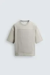 Sudadera de corte relajado confeccionada en tejido de algodón, con cuello redondo y manga corta. Presenta una aplicación de parche combinado a tono en la parte frontal y trasera.