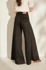 Pantalón de lino blanco de corte wide leg, con diseño amplio y costuras pespunteadas a contratono.
