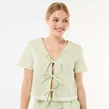 Pijama de dos piezas de cuadros vichy en tonos verde claro y blanco. Incluye una camisa de manga corta con escote en V y cierre frontal mediante lazos, y un short con cintura elástica y cordón ajustable. Ambas prendas cuentan con detalles de ondas bordadas en los bordes.