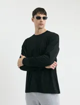Remera de manga larga color negro, con cuello redondo y puños en punto canalé.