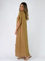 Vestido largo de lino color terracota, con escote en V y detalles de flecos en el cuello, mangas y en la parte inferior de la falda.