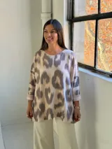 Sweater de punto con estampado abstracto tipo animal print en tonos gris y beige, de corte holgado, cuello redondo y mangas tres cuartos con dobladillo.