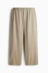Pantalón de algodón color beige, estilo casual con corte relajado, cintura elástica con cordón de ajuste oculto y bolsillos al bies y traseros.