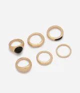 Kit de seis anillos dorados de metal con diseño bold y orgánico, que incluye piezas de diferentes grosores y detalles con incrustaciones de resina negra.