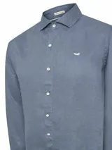 Camisa de manga larga para hombre, confeccionada en lino 100% orgánico con acabado stone wash. Diseño clásico con bolsillo en el pecho y logo bordado en contraste.
