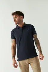 Remera polo blanca de manga corta, con cuello clásico, cierre de tres botones y logo estampado en el pecho.