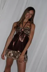 Vestido corto azul metalizado con diseño cut-out, argolla central en el busto, tirantes halter y falda con volado en el ruedo.