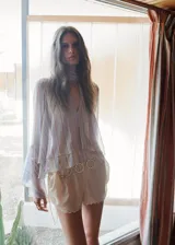 Blusa de poliéster con estampado de rayas, cuello con pañuelo integrado y detalle de abertura en V, de corte recto y mangas largas abullonadas con volantes.