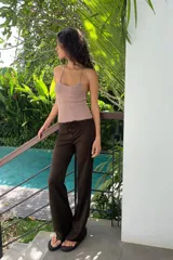 Top crop de tejido de punto con hilo metalizado, diseño de cuello halter y tiras finas cruzadas en la espalda.