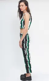 Pantalón de corte recto y tiro medio-alto, confeccionado en crepé con un diseño estampado geométrico en bloques de color verde, negro y blanco. Presenta cierre frontal con botón y pretina estructurada.