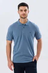 Remera polo de piqué de algodón color azul, de manga corta, con cuello camisero, cierre frontal de dos botones y pequeño logo bordado en el pecho.