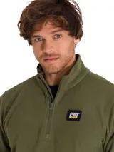 Buzo polar de microfibra color verde oliva, con cuello alto y cierre de cuarto de longitud. Presenta el logo de la marca Caterpillar aplicado en el pecho.