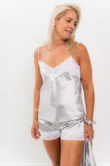 Conjunto de pijama compuesto por una musculosa de satén con escote en V y detalles de puntilla blanca, y un short a juego con elástico en la cintura y terminación de puntilla en el ruedo.