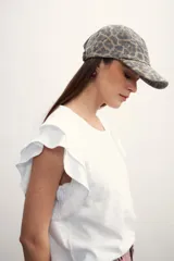 Gorro tipo gorra con visera, confeccionado en tela con estampado animal print de leopardo en tonos grises y marrones.