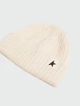 Gorro tipo beanie de lana en color crema, con tejido acanalado y parche con estrella negra en el frente.