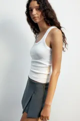 Falda pantalón de tiro medio color negro, con detalle de abertura en el delantero y cierre lateral con cremallera oculta.