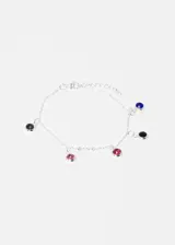 Pulsera de acero quirúrgico color plateado con dijes redondos de strass en colores azul, negro y rosa.