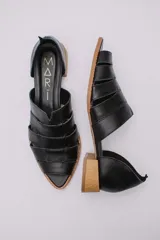 Sandalias de cuero negro con talón descubierto, tiras anchas entrecruzadas en el empeine y taco bajo de madera.