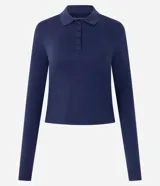 Blusa tipo polo de manga larga confeccionada en algodón, con cuello clásico y cierre frontal de botones. Presenta un diseño de corte regular y acabado suave.