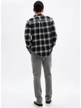 Pantalón de jean corte slim en color gris lavado, con cierre de botón y cremallera, bolsillos laterales y traseros.