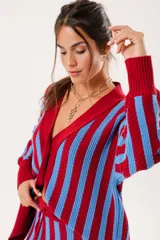 Saco oversize tejido con diseño de rayas verticales en colores rojo y azul. Presenta escote en V, cierre frontal con botones y puños y ruedo acanalados.