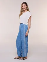 Pantalón wide leg de lyocell color azul con estampado paisley, cintura elástica y bolsillos laterales. Cuenta con una tira lateral decorativa con diseño ornamental.