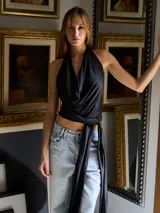 Minivestido negro con escote halter drapeado y lazo lateral.