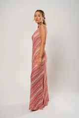 Vestido midi de crochet con diseño de ondas en tonos rojo, rosa y beige. Tiene un solo hombro y tajos laterales.