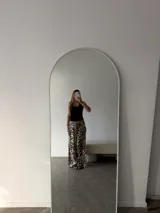 Pantalón negro de algodón y viscosa, con estampado de lunares blancos y corte holgado.