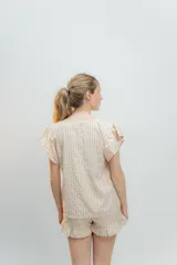 Pijama de algodón estampado Vichy, compuesto por una blusa de escote redondo y sin mangas con volados, y un short con elástico en la cintura y volados en el ruedo.