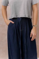 Jean de calce amplio y relajado, color azul, con pierna extra ancha y caída fluida. Diseño de tiro alto con pinzas delanteras y lazo regulable en la cintura. Cuenta con bolsillos laterales y traseros.