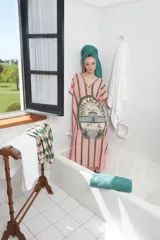 Túnica larga celeste con rayas verticales marrones y estampado central con el logo de un hotel. Tiene cuello en V con detalle de puntilla y tajos laterales.